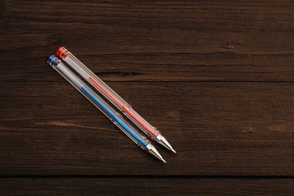 A set of gel pens on a blue background.