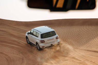 Dubai, Birleşik Arap Emirlikleri - 01 Temmuz 2021: Kum çölünde yarış. Yarış yarışı çölü. Araba toz bulutlarıyla yoldan çıkıyor. Yabanda engellerle yarışan off road aracı