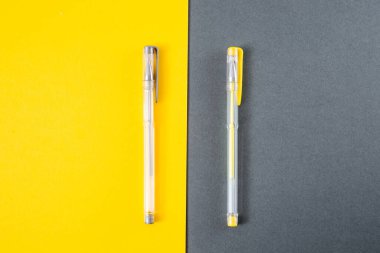 Sarı ve gri arka planda sarı ve gri jel kalemler.