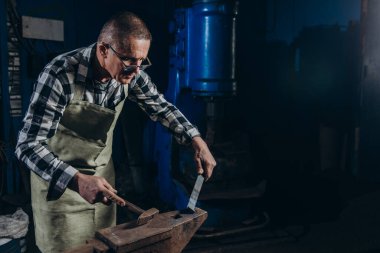 Usta bir demirci demirden bir çekiçle vurur..