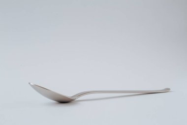 Silver shiny spoon on white background, kitchenware, copy space.