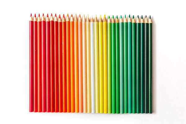 Цветные разноцветные деревянные карандаши на белом фоне.