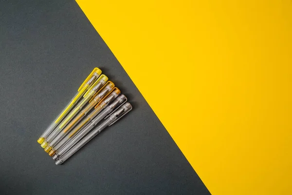 stock image Yellow and gray gel pens on a yellow and gray background.