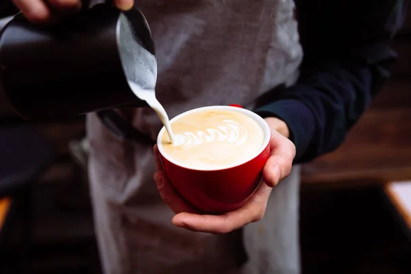 バリスタは新鮮な牛乳をコーヒーカップに注ぐ フラワーラテアート — ストック写真