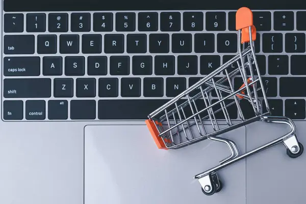 Online shopping concept. shopping cart, laptop on the desk.