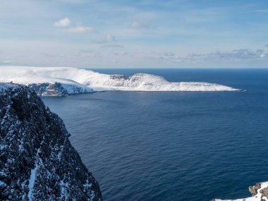 Snow covered peninsula and rocky cliffs at North Cape, Norway