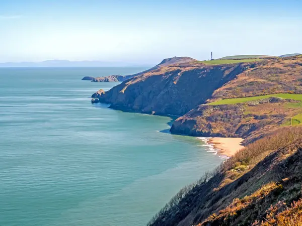 Galler 'in Cardigan Körfezi' ndeki Ceredigion Coast Yolu 'ndaki kayalıklardan Penbryn sahili manzarası