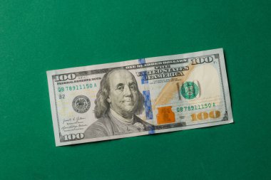 Parlak yeşil bir yüzeye yüz dolarlık banknot serilmiştir. Tasarım Benjamin Franklins 'in portresini belirgin bir şekilde gözler önüne seriyor, detaylı detaylar, eğitim amacıyla ideal..