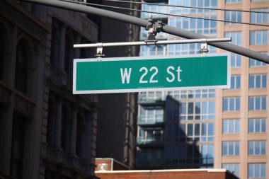 Manhattan 'ın göbeğindeki bir direkte asılı yeşil büyük batı 22. Cadde tabelası.