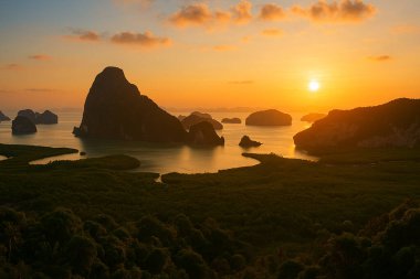 Tayland 'da Phang Nga Körfezi' nde nefes kesici bir gün doğumu. Altın ışık, aşağıdaki dramatik kireçtaşı karstlarını ve sakin suları aydınlatıyor..