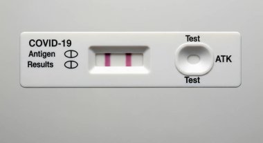 Pozitif COVID-19 antijen hızlı testinin (ATK) iki çizgi göstermesi, virüsün pozitif bir sonucu olduğunu gösteriyor.