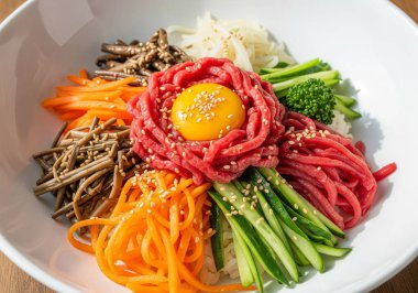  Kore mutfağı, özenle sunulmuş bir kase Yukhoe Bibimbap, taze malzemelerini sergiliyor ve renkleri davet ediyor..