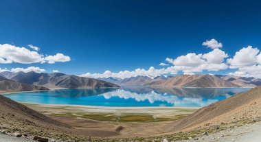 Pangong Tso Gölü 'nün nefes kesici manzarası berrak bir gökyüzünün altındaki engebeli Himalaya dağlarının arasına kurulmuş canlı mavi sularıyla..