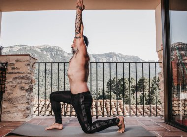 Evde spor yapan gömleksiz bir adam.