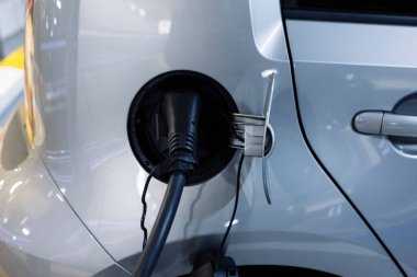 Tip 2 elektrik kablosu, elektrikli bir arabanın şarj prizine bağlı. Arabanıza yakıt ikmali yapmanın modaya uygun yaşam tarzı kavramı.