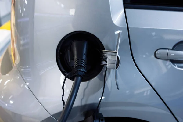 Tip 2 elektrik kablosu, elektrikli bir arabanın şarj prizine bağlı. Arabanıza yakıt ikmali yapmanın modaya uygun yaşam tarzı kavramı.