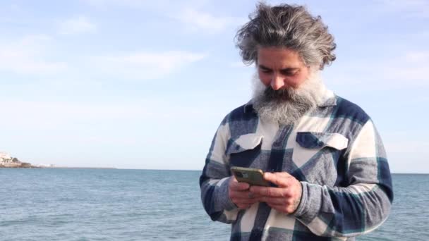 Relaxed Bearded Man Seashore While Chatting Smartphone — Stock Video