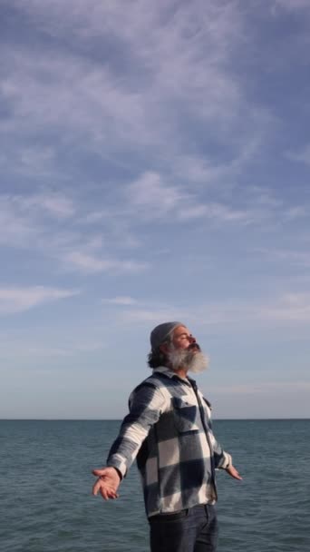 ビーチから新鮮な空気を呼吸するヒップスターの男の肖像 晴れた冬の日に海辺でリラックスした中年の男 — ストック動画