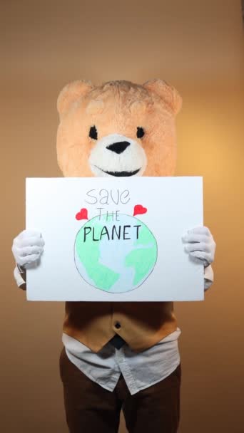 Man Teddy Bear Head Yellow Background Points Sign Says Planet — Video Stock
