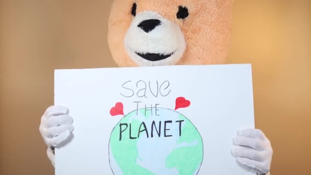 Людина Плюшевою Головою Тедді Тримає Знак Якому Написано Врятуйте Планету — стокове відео