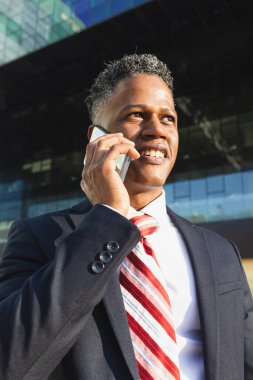 Young successful businessman working talking on the phone near modern office center outside