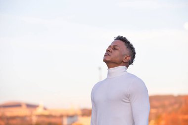 Side view portrait of a man breathing deep air in the city.