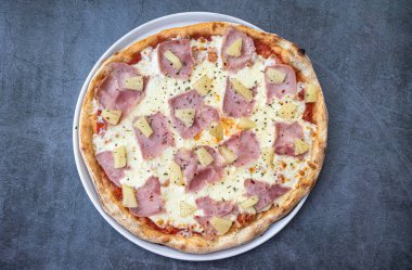 Delicious Hawaiian-style pizza on a rustic background. top view clipart