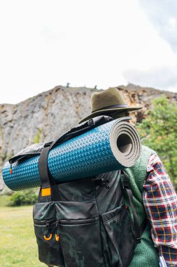 Şapkası ve paspası olan bir sırt çantasının arka görüntüsü. Bağımsız yaşam tarzı