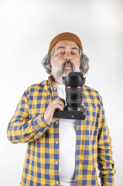 Beyaz ya da şeffaf bir arkaplanda fotoğraf çekmeye çalışan sakallı fotoğrafçı.