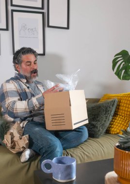 Heyecanlı adam evde online alışveriş paketi açıyor