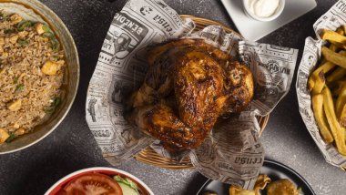 Çeşitli mezelerle servis edilen kızarmış tavuğun genel görünüşü, baştan çıkarıcı ve baştan çıkarıcı bir yemek yaratıyor.