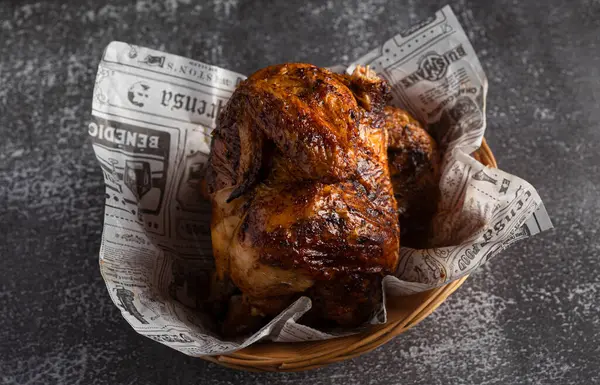 Lezzetli kızarmış tavuk, hasır sepette dinleniyor. Gazete ile hazırlanmış, eğlenmeye hazır.