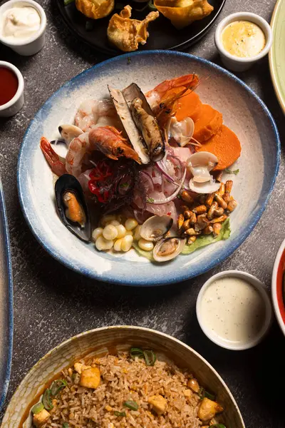 Farklı deniz ürünleri, tatlı patates ve mısırla birlikte taze ceviche tabağı ve diğer Peru mutfak yemekleri sunulmaktadır.