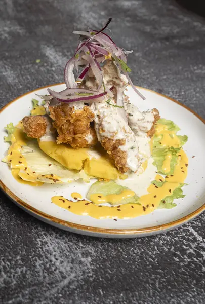 Lezzetli baharatlı mandongo, yanında huancana soslu haşlanmış patates ve geleneksel Peru usulü corna ile servis edilir.