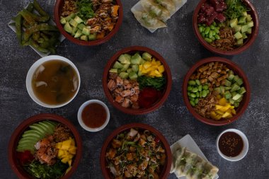 Canlı Asya yemekleri, dürtme kaseleri, miso çorbası, ve bir masaya yerleştirilmiş gyoza hamur tatlısı.