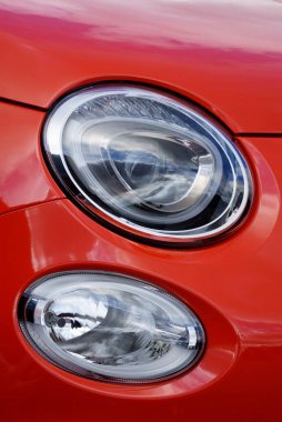 Kırmızı klasik İtalyan Fiat 500 arabasının farları.