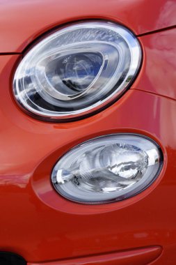 Kırmızı klasik İtalyan Fiat 500 arabasının farları.