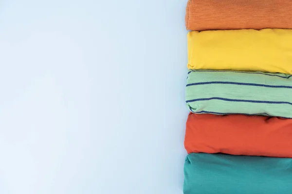 Gros Plan Des Vêtements Shirt Colorés Roulés Sur Fond Table — Photo