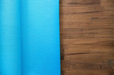 close up of blue yoga mat on the table with copy space,  sport and healthy concept