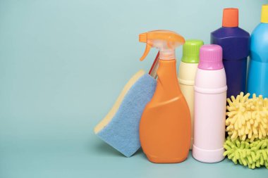 House cleaning plastic product on green table background, home service or housekeeping concept