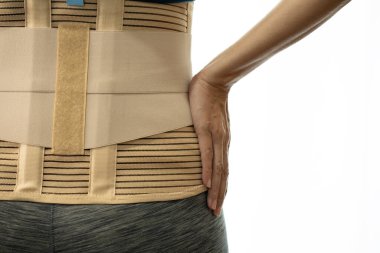 young woman wearing back support for protect her back, medicine and healthy concept