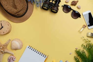 Flat lay concept of travel accessories vacation trip and long summer weekend planning on yellow table with blank space for text background.