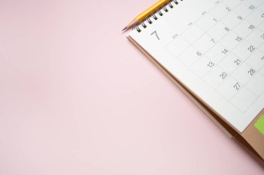 Pembe masa arkaplanındaki takvimi kapat, iş toplantısı ya da seyahat planlama konseptini planla