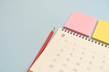 mavi masa arkaplanındaki takvim ve kalemi kapat, iş toplantısı ya da seyahat planlama konseptini planla