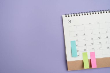 Menekşe masa arkaplanındaki takvimin kapatılması, iş toplantısı veya seyahat planlama konsepti için planlama