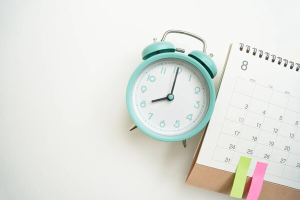 close up of calendar and alarm clock on the white table background, planning for business meeting or travel planning concept