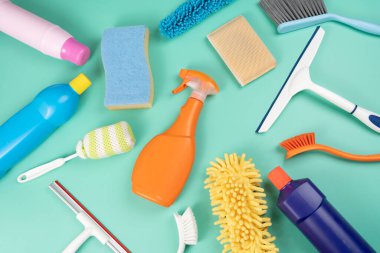 House cleaning plastic product on green table background, home service or housekeeping concept