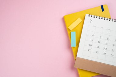 Pembe masa arkaplanındaki takvimi kapat, iş toplantısı ya da seyahat planlama konseptini planla