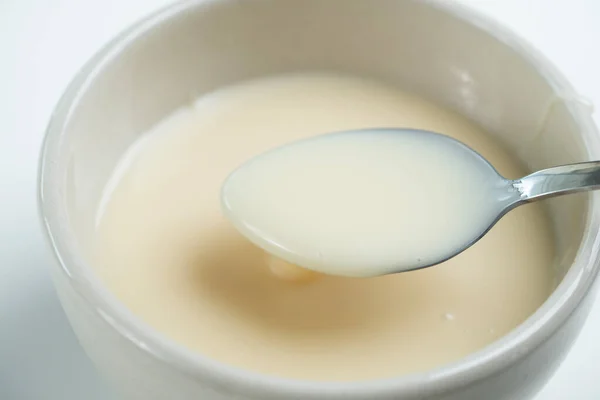 Zblízka Kondenzovaného Mléka Lžící Izolovanou Bílém Pozadí Koncept Složek Potravin — Stock fotografie