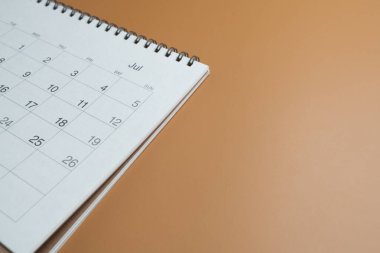 kahverengi masa arkaplanındaki takvimin kapatılması, iş toplantısı ya da seyahat planlama konsepti